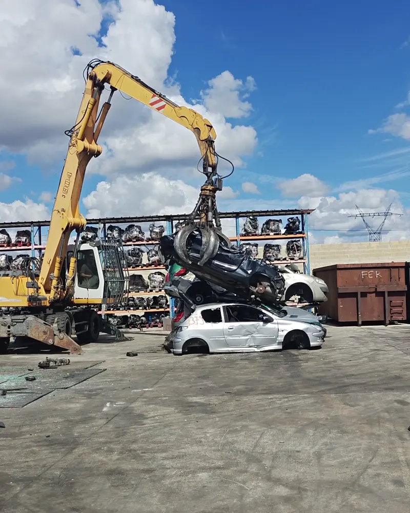 Grappin de notre centre VHU agréé soulevant une voiture hors d'usage pour destruction